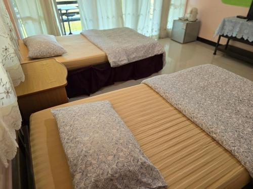 a room with three beds in a room at ภูร์ชรินท์ รีสอร์ท in Ban Than Phra
