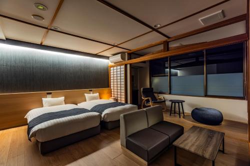 a bedroom with a bed and a chair and a table at AWA Nishi-Izu in Numazu