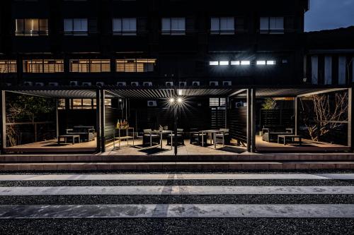a building with tables and chairs outside at night at AWA Nishi-Izu in Numazu