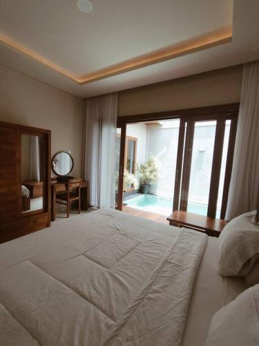 a large bedroom with a large bed and a mirror at Villa Maha IV in Dalung