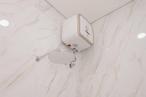 a white toilet in a white marble bathroom at Villa Maha IV in Dalung