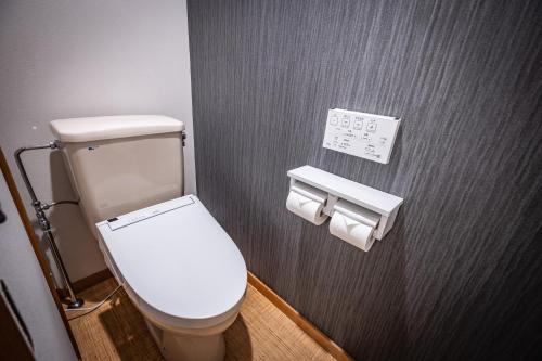 a bathroom with a toilet and two rolls of toilet paper at AWA Nishi-Izu in Numazu