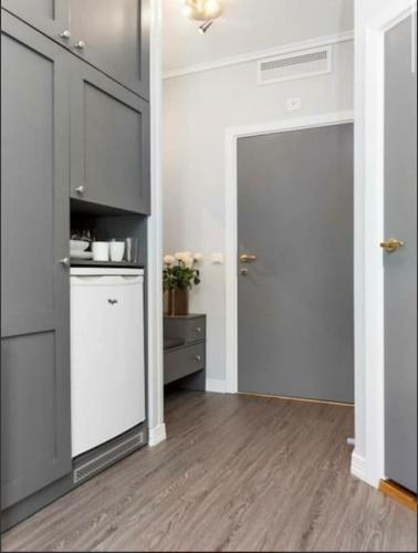 a kitchen with a refrigerator and a door to a room at Studio Apartment Oslo AirPort in Gardermoen