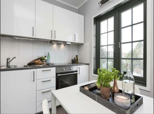 cocina con armarios blancos y encimera blanca en Studio Apartment Oslo AirPort en Gardermoen