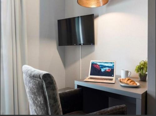 escritorio con ordenador portátil y bandeja de comida en Studio Apartment Oslo AirPort, en Gardermoen
