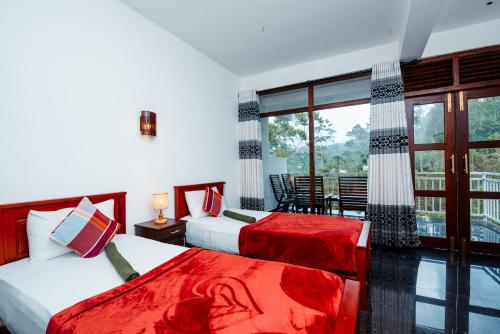 a bedroom with two beds and a balcony at Adams Peak Inn in Adams Peak