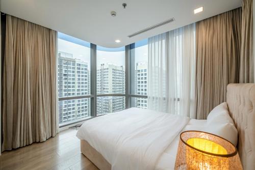 a bedroom with a large bed and a large window at LANMARK 81 Enigma Residences in Ho Chi Minh City