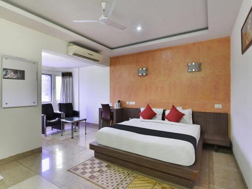 um quarto com uma cama, uma secretária e cadeiras em HOTEL RAJMAHAL GREEN em Bhiwadi