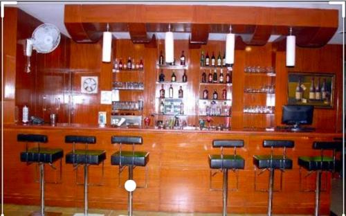 um bar de madeira com bancos de bar num quarto em HOTEL RAJMAHAL GREEN em Bhiwadi