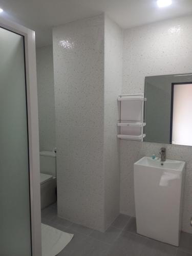 bagno con servizi igienici, lavandino e specchio di Dania a Centro di Pattaya