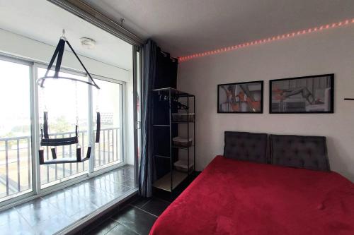 カップ・ダグドにあるCap d'Agde Naturist Héliopolis 81のベッドルーム1室(赤いベッド1台、大きな窓付)