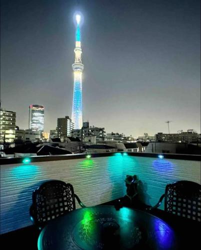 a table and chairs with a view of the eiffel tower at Colorful House SKY TREE in Tokyo