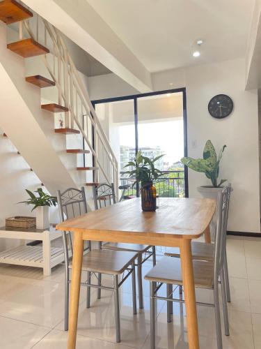 a dining room with a wooden table and chairs at The Family Suite at the Mactan Airport in Pusok