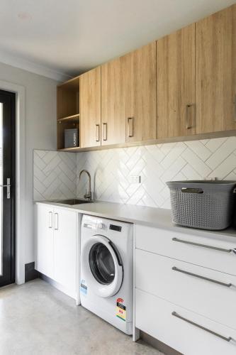 a kitchen with a washing machine and a sink at 44onRoaring - in the Huon Valley in Surveyors Bay