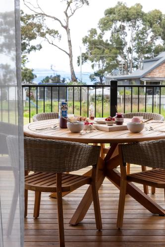 a wooden table with bowls of food on a deck at 44onRoaring - in the Huon Valley in Surveyors Bay