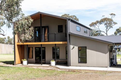 a house with a balcony on top of it at 44onRoaring - in the Huon Valley in Surveyors Bay
