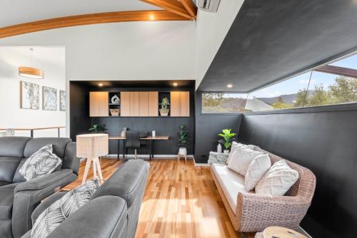 a living room with a couch and a table at Tree Top Views - Magnificent 4 Bedroom House - 3 Minutes to MONA in Rosetta