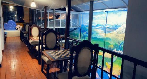 a balcony with chairs and a mural of a mountain at Four Season Hostel in Bogotá