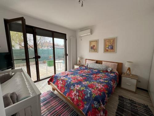 a bedroom with a bed and a large window at Large Guest House Apartment with Parking and Patio Garden, Near City Center & Kazanlak Stadium in Kazanlŭk