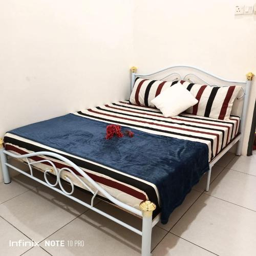 De'Bendang Homestay Pendang في Pendang: سرير عليه بطانية ووسائد زرقاء