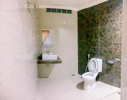 a bathroom with a toilet and a sink at WISMA MIRAH 1 in Kamparganya