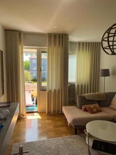 een woonkamer met een bank en een tafel bij Mysig lägenhet eurovision 2024 in Malmö