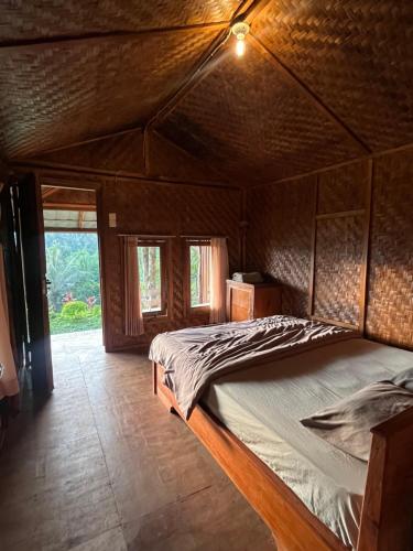 a bedroom with a large bed in a house at Tetebatu Jungle Vibes in Tetebatu