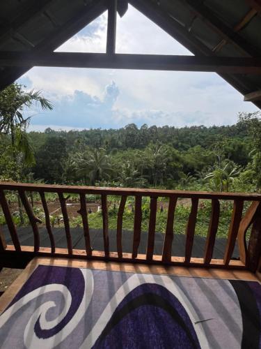 a balcony with a view of the jungle at Tetebatu Jungle Vibes in Tetebatu