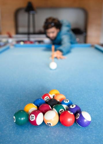 a man playing pool with a group of balls on a pool table at The Oasis Mussoorie - A Member of Radisson Individuals in Mussoorie
