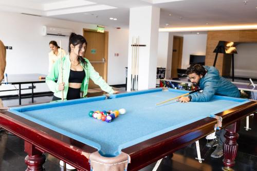 a group of people standing around a pool table at The Oasis Mussoorie - A Member of Radisson Individuals in Mussoorie