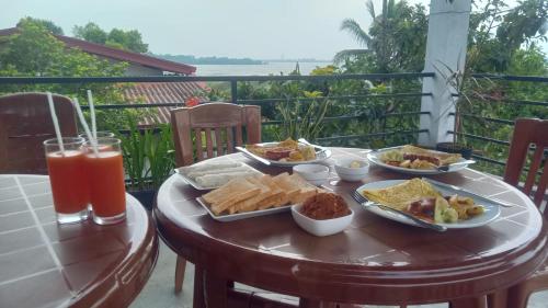 a table with food and drinks on a balcony at Lake Edge Resort in Anuradhapura