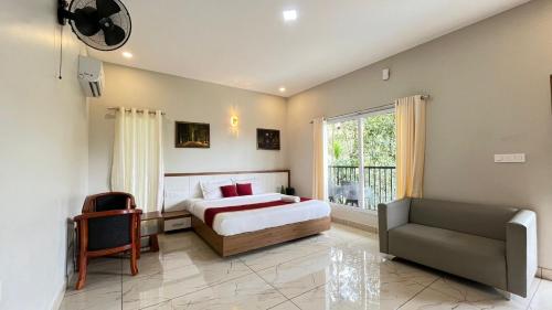 Un dormitorio con una cama y una silla y una ventana. en Mountain Vibes Resort Wayanad, en Wayanad