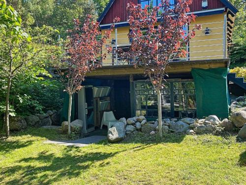dom z drzewem przed nim w obiekcie 4 person holiday home in KIVIK w mieście Kivik