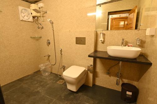 a bathroom with a toilet and a sink at Sound of Forest in Āmbavna