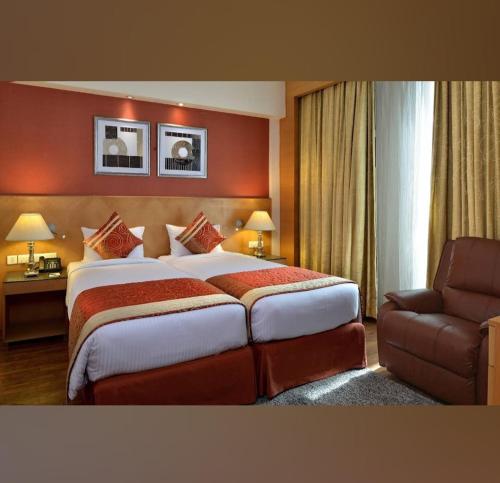 um quarto de hotel com uma cama grande e uma cadeira em HOTEL FLAMINGO em Jaipur