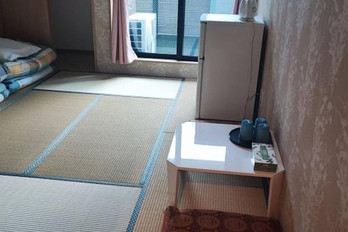 大阪全新上线花跡民宿4号館203，关西机场直达萩之茶屋出站1分钟！难波，心斋桥4分钟车程！的一间设有两张床和一张桌子的房间