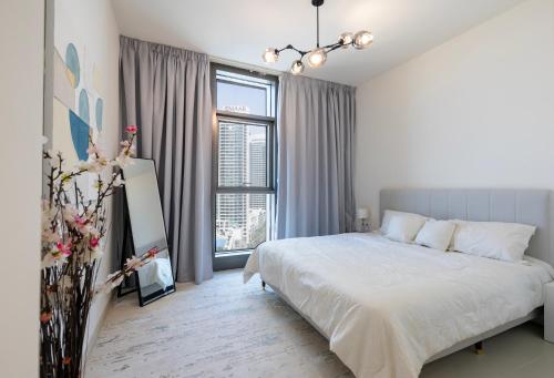 a white bedroom with a bed and a large window at Burj Crown 2BR Apartment with Panoramic Burj Khalifa View in Dubai