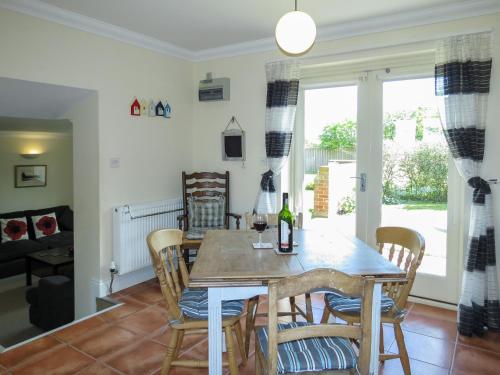 uma sala de jantar e sala de estar com mesa e cadeiras em 3 Hazlewood em Aldringham