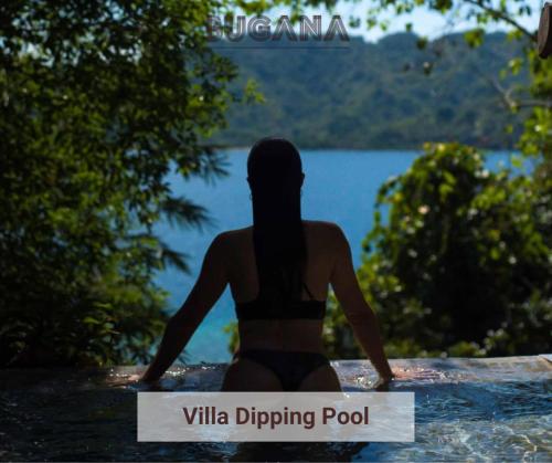 a woman in a bikini looking out at a lake at Bugana Beach and Dive Resort in Manlocahoc