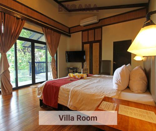 a bedroom with a large bed in a room at Bugana Beach and Dive Resort in Manlocahoc
