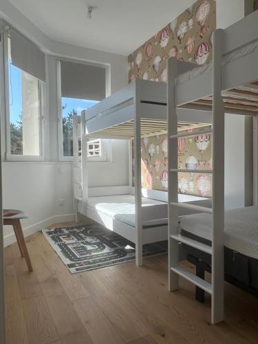 une chambre avec deux lits superposés et une fenêtre dans l'établissement Appartement avec vue sur la Pinède grande terrasse, à Le Touquet-Paris-Plage