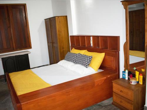 a bed with a wooden headboard in a room at pvc 2 in Hikkaduwa