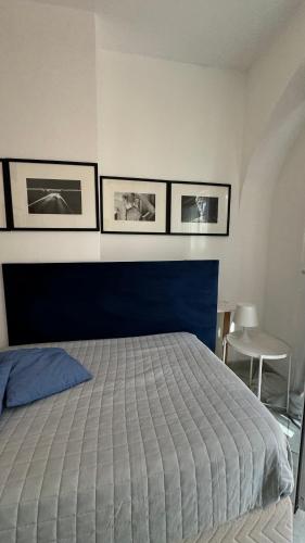 a bedroom with a bed and three pictures on the wall at CAPRI DESIGN ROOM in Capri