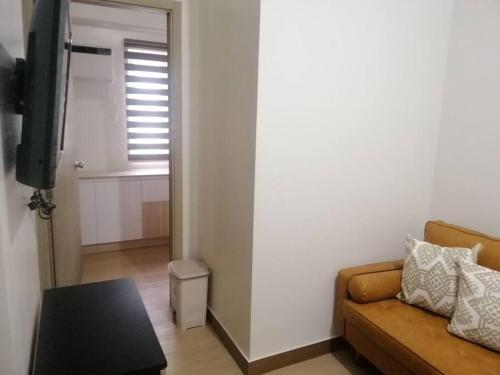 una sala de estar con un sofá y una mesa en 2BR Fully Furnished Unit at Fairview QC, en Manila