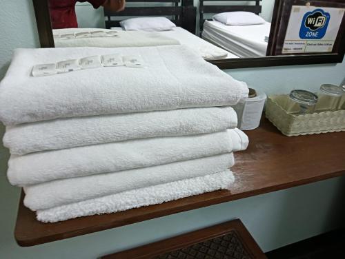 een stapel handdoeken op een tafel in een hotelkamer bij Boondee House in Mae Hong Son