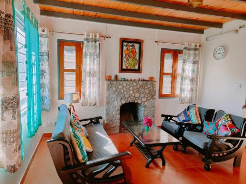 a living room with a couch and a fireplace at Fursat, exclusive solitude! in Rāmgarh