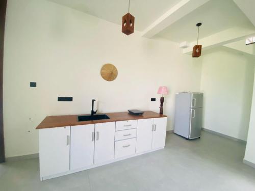 eine Küche mit weißen Schränken und einem Kühlschrank in der Unterkunft Amelia Misty Hills in Kandy