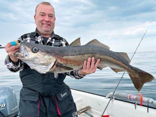 a man holding a large fish on a boat at 6 person holiday home in skudeneshavn-By Traum in Skudeneshavn