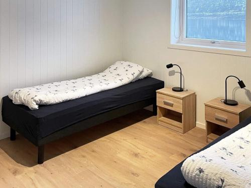 a bedroom with a bed and a nightstand and a window at Holiday home Ålfoten in Davik