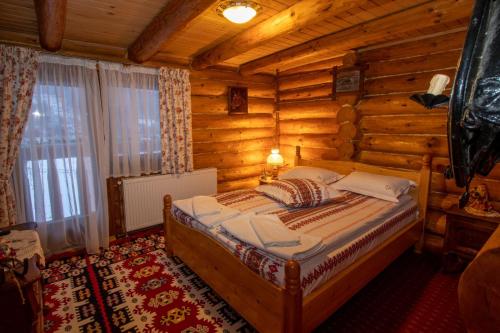 a bedroom with a bed in a log cabin at Cabana Popasul Calaretului in Râşnov